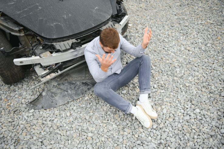 Frustrated man near a broken car