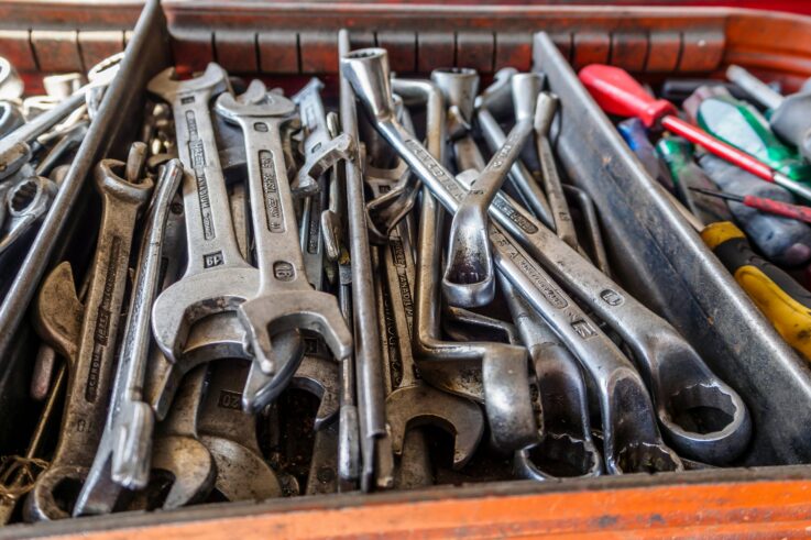 Close-up view of assorted wrenches and screwdrivers on a workbench