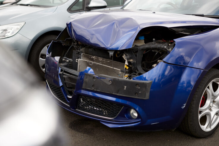 Detail of car damaged in motor vehicle accident parked in garage repair shop