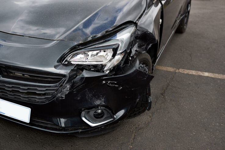 Detail of damage to headlight of vehicle in car park