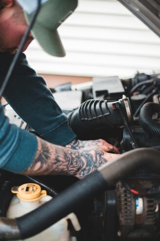 Automotive technician performing repairs near the engine