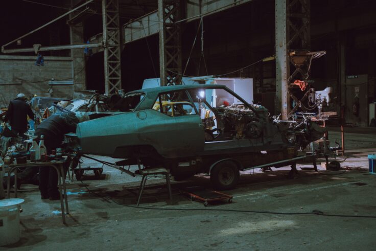 Mechanic performing repairs on an old-fashioned car in the trunk