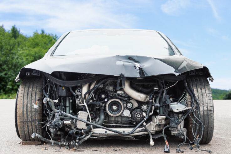 Front view of crashed car with damaged car parts on the street