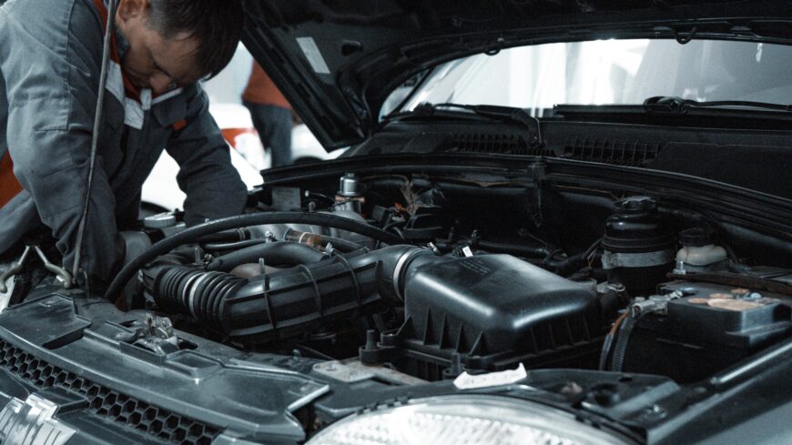 Mechanic performing repairs near the engine bay