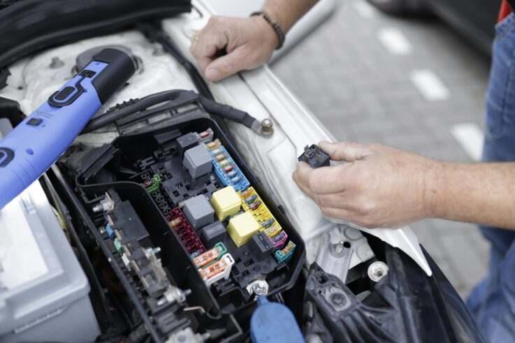 Mechanic working on white car engine