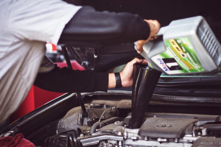 Mechanic pouring coolant into the engine